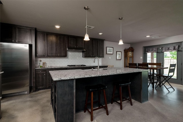 14447 Warbler Ln, Haslet, TX 76052 - kitchen featuring stainless steel appliances, finished concrete flooring, decorative backsplash, a breakfast bar area, and recessed lighting
