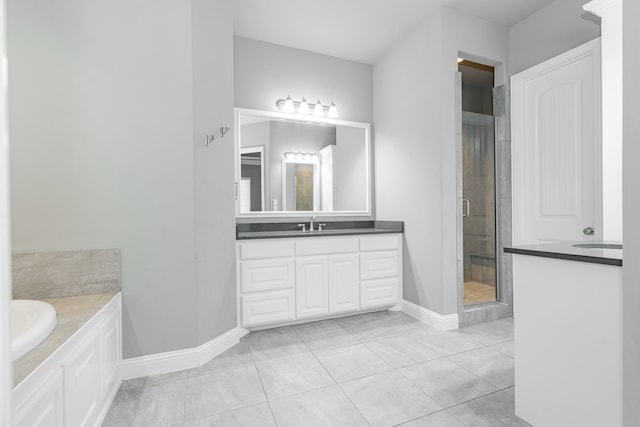 913 Colby Bluff Dr, Rockwall, TX 75087 - full bath with vanity, a stall shower, a bath, baseboards, and tile patterned floors