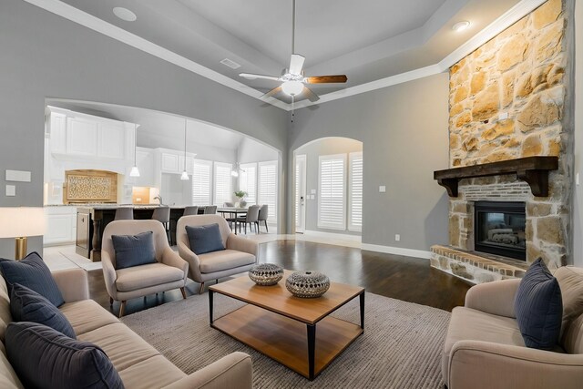 913 Colby Bluff Dr, Rockwall, TX 75087 - living area with baseboards, arched walkways, ceiling fan, light wood-type flooring, and a tray ceiling