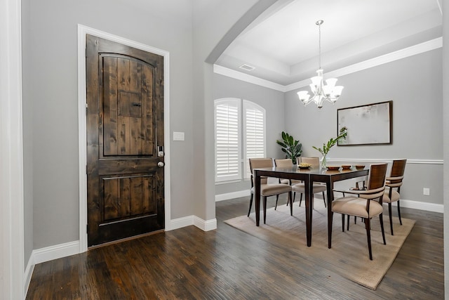 913 Colby Bluff Dr, Rockwall, TX 75087 - dining space featuring wood finished floors, baseboards, a tray ceiling, arched walkways, and a chandelier
