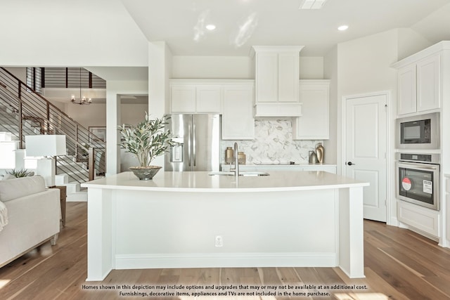 12605 Rocky Top Rd, Godley, TX 76044 - kitchen featuring black appliances, a kitchen island with sink, decorative backsplash, light wood finished floors, and light countertops