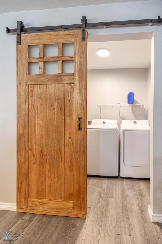 601 Westmoreland St, Abilene, TX 79603 - washroom with a barn door, washer and dryer, wood finished floors, and baseboards
