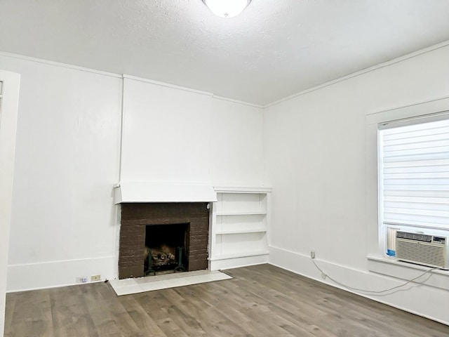 421 Jackson St, Krum, TX 76249 - unfurnished living room with wood finished floors, a brick fireplace, cooling unit, and baseboards