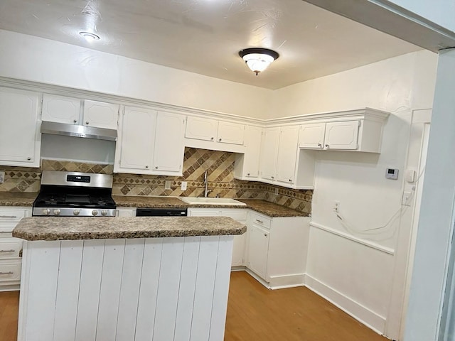 421 Jackson St, Krum, TX 76249 - kitchen featuring stainless steel range with gas stovetop, a sink, under cabinet range hood, light wood-style flooring, and white cabinetry