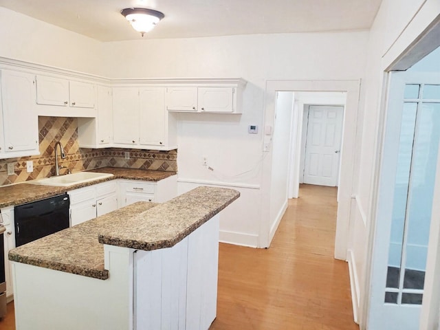 421 Jackson St, Krum, TX 76249 - kitchen with a sink, black dishwasher, light wood-style flooring, tasteful backsplash, and white cabinets