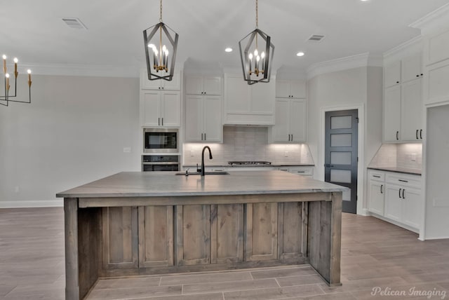 507 Cocodrie Dr, Bossier City, LA 71112 - kitchen with appliances with stainless steel finishes, a chandelier, a sink, ornamental molding, and tasteful backsplash