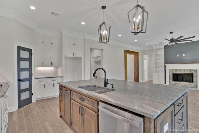 507 Cocodrie Dr, Bossier City, LA 71112 - kitchen featuring stainless steel dishwasher, a sink, light wood-style flooring, ceiling fan, and white cabinetry
