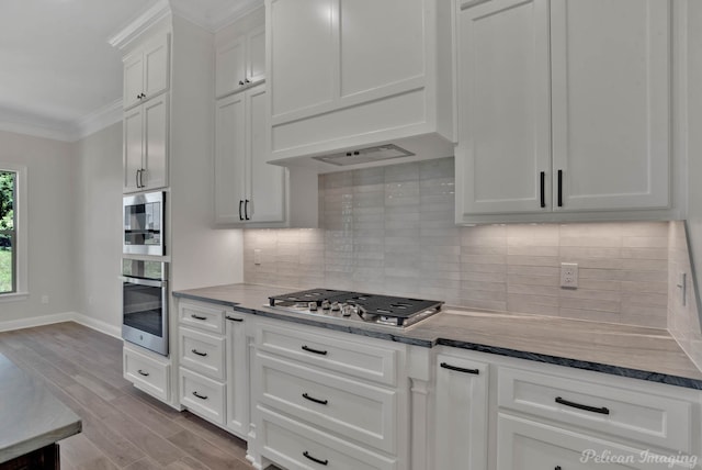 507 Cocodrie Dr, Bossier City, LA 71112 - kitchen featuring appliances with stainless steel finishes, premium range hood, wood finished floors, crown molding, and baseboards