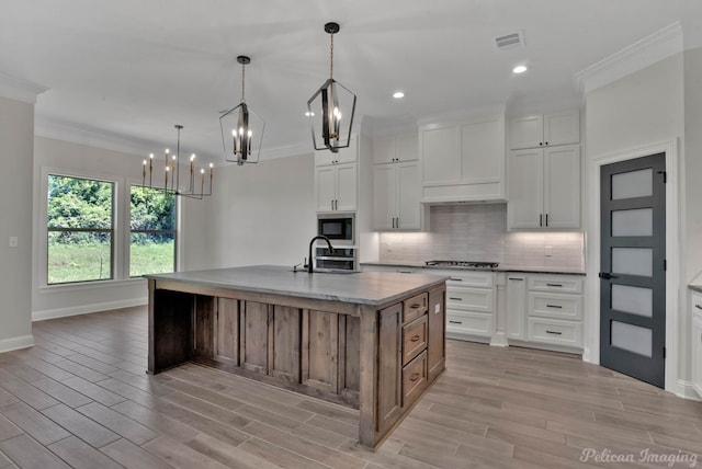 507 Cocodrie Dr, Bossier City, LA 71112 - kitchen with a sink, a chandelier, built in microwave, crown molding, and light wood-type flooring