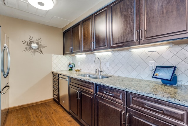 6211 W NW Hwy Unit 1504, Dallas, TX 75225 - kitchen with a sink, appliances with stainless steel finishes, dark brown cabinets, light stone countertops, and light wood-style flooring