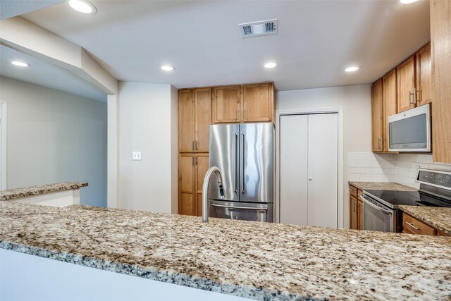 14277 Preston Rd Unit 524, Dallas, TX 75254 - kitchen with appliances with stainless steel finishes, recessed lighting, light stone counters, and tasteful backsplash