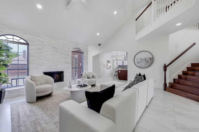 9320 Vista Cir, Irving, TX 75063 - living area with a chandelier, high vaulted ceiling, a stone fireplace, light marble finish floors, and stairs