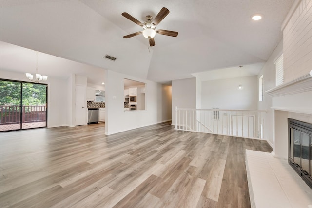 7616 Jamie Renee Ln, North Richland Hills, TX 76182 - unfurnished living room featuring ceiling fan, a chandelier, high vaulted ceiling, a brick fireplace, and light wood-style flooring