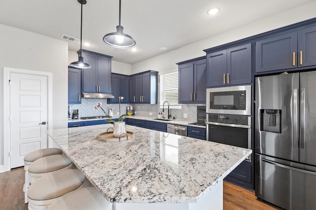 3817 Stonewood Dr, Little Elm, TX 75068 - kitchen with appliances with stainless steel finishes, light stone countertops, blue cabinets, a breakfast bar, and recessed lighting