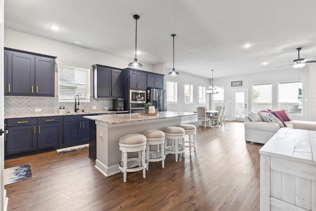 3817 Stonewood Dr, Little Elm, TX 75068 - kitchen with a sink, stainless steel appliances, a kitchen bar, dark wood-type flooring, and plenty of natural light