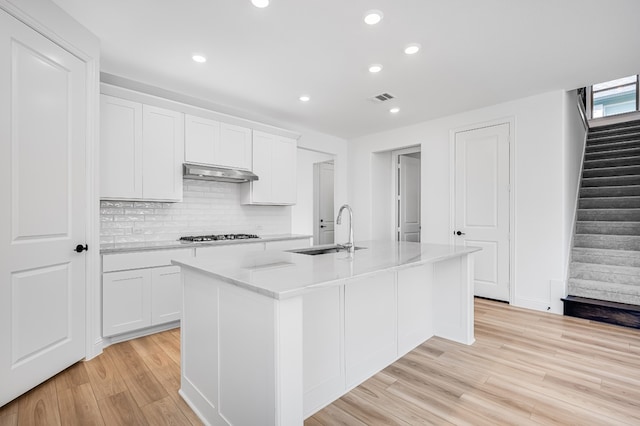 4251 Arlington Ave, Mckinney, TX 75071 - kitchen with a sink, light wood-style flooring, an island with sink, under cabinet range hood, and recessed lighting