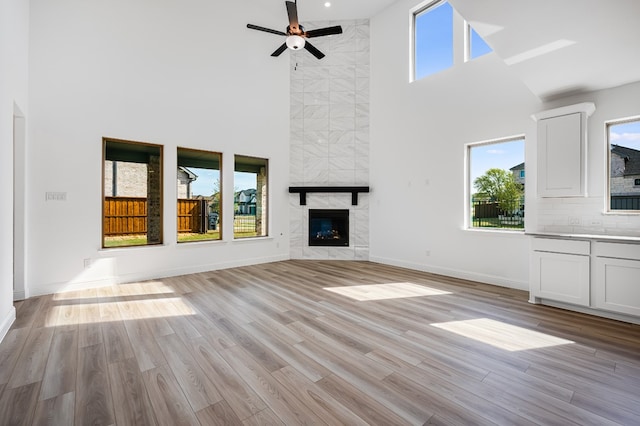 4251 Arlington Ave, Mckinney, TX 75071 - unfurnished living room featuring a high ceiling, healthy amount of natural light, a ceiling fan, a fireplace, and baseboards