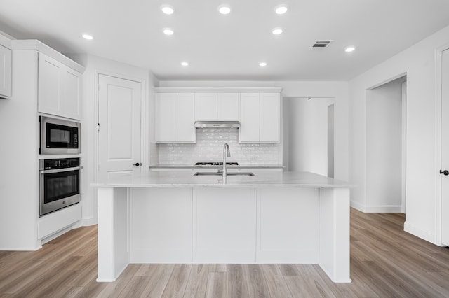4251 Arlington Ave, Mckinney, TX 75071 - kitchen with oven, built in microwave, a sink, under cabinet range hood, and light wood-type flooring