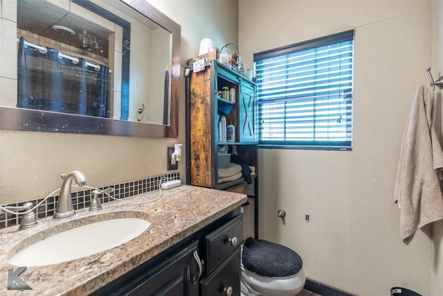 890 Vine St, Abilene, TX 79602 - bathroom featuring a shower stall, toilet, vanity, and decorative backsplash