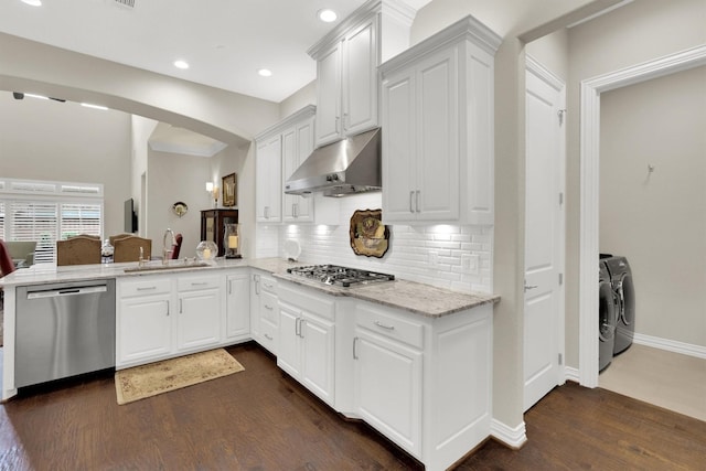4721 Bayview Dr, Plano, TX 75093 - kitchen featuring appliances with stainless steel finishes, separate washer and dryer, range hood, a sink, and arched walkways