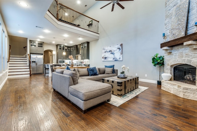 5913 Lewis St, Dallas, TX 75206 - living room featuring ceiling fan, dark wood-style flooring, stairs, a high ceiling, and arched walkways
