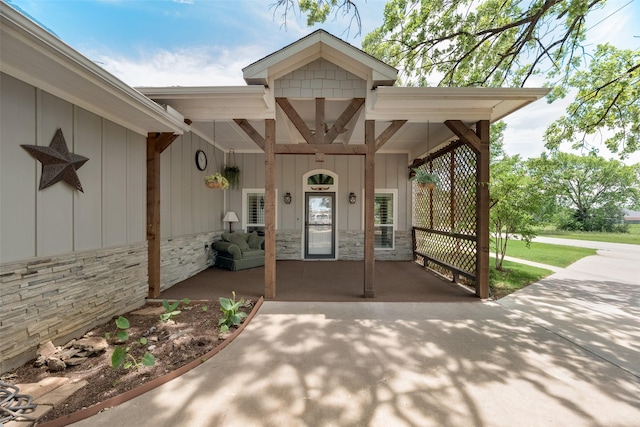 760 E Northside Dr, Pilot Point, TX 76258 - doorway to property featuring a porch, stone siding, and board and batten siding