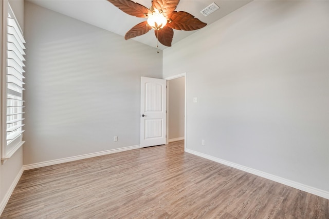 760 E Northside Dr, Pilot Point, TX 76258 - empty room with a ceiling fan, light wood finished floors, a towering ceiling, and baseboards