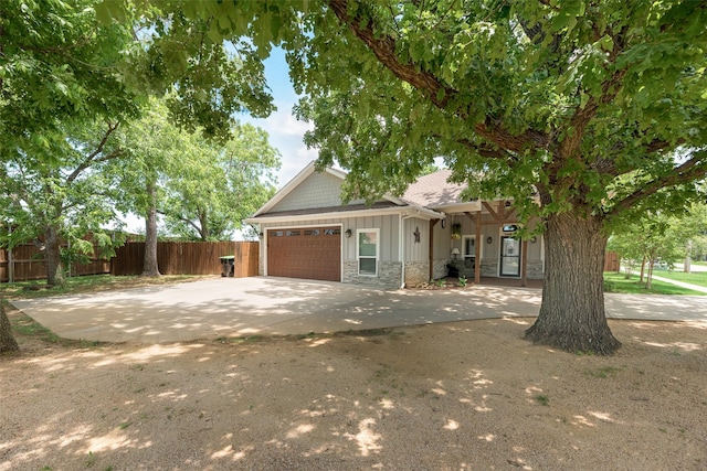 760 E Northside Dr, Pilot Point, TX 76258 - view of front of home featuring stone siding, a garage, board and batten siding, and driveway