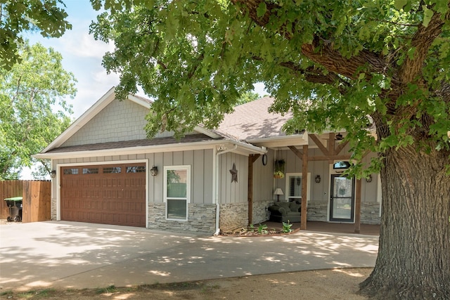 760 E Northside Dr, Pilot Point, TX 76258 - view of front of property featuring stone siding, board and batten siding, a garage, roof with shingles, and driveway