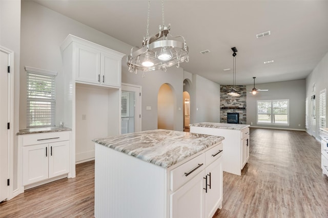 760 E Northside Dr, Pilot Point, TX 76258 - kitchen with a kitchen island, open floor plan, a ceiling fan, light wood-type flooring, and arched walkways