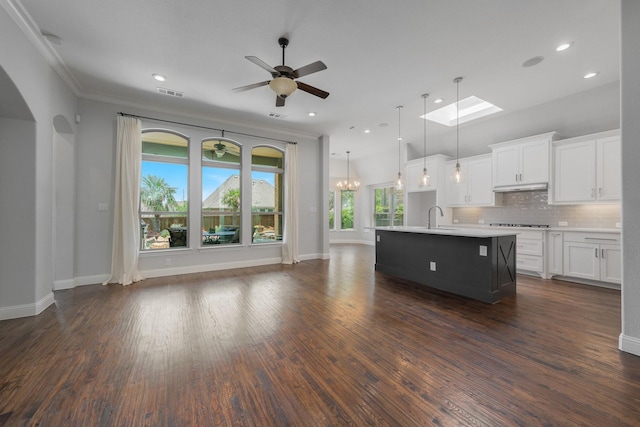 7340 San Felipe Dr, Irving, TX 75039 - kitchen with open floor plan, light countertops, an island with sink, white cabinets, and ornamental molding