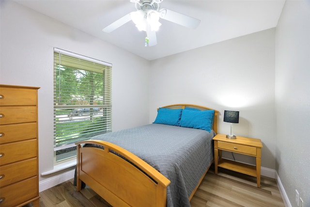 909 Redwood Dr, Richardson, TX 75080 - bedroom with wood finished floors, baseboards, and a ceiling fan