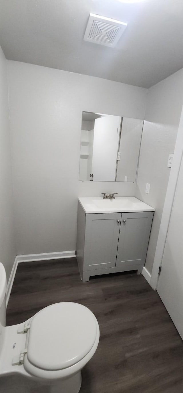 1806 Maryland Ave, Dallas, TX 75216 - half bathroom with toilet, vanity, wood finished floors, and baseboards