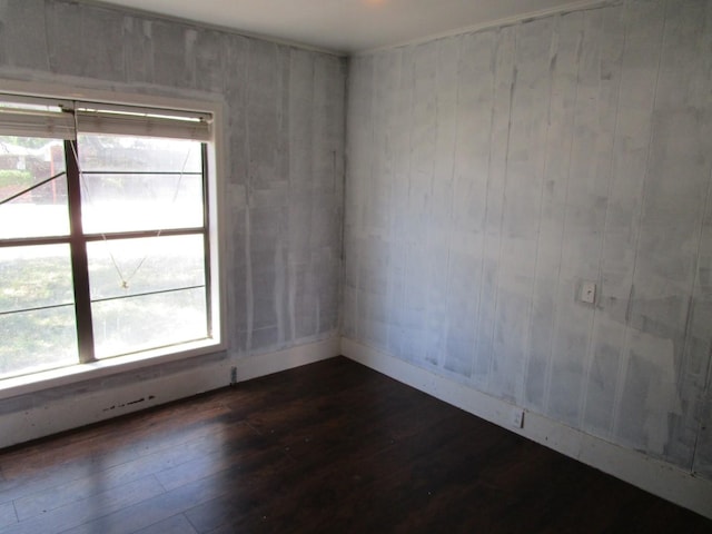 841 S 5th Ave, Munday, TX 76371 - spare room featuring dark wood-type flooring, healthy amount of natural light, and baseboards
