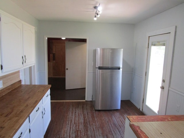 841 S 5th Ave, Munday, TX 76371 - kitchen featuring freestanding refrigerator, white cabinetry, and dark wood-type flooring
