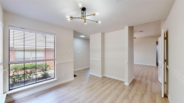 6916 Moccasin Dr, Plano, TX 75023 - empty room featuring a chandelier, light wood finished floors, and baseboards