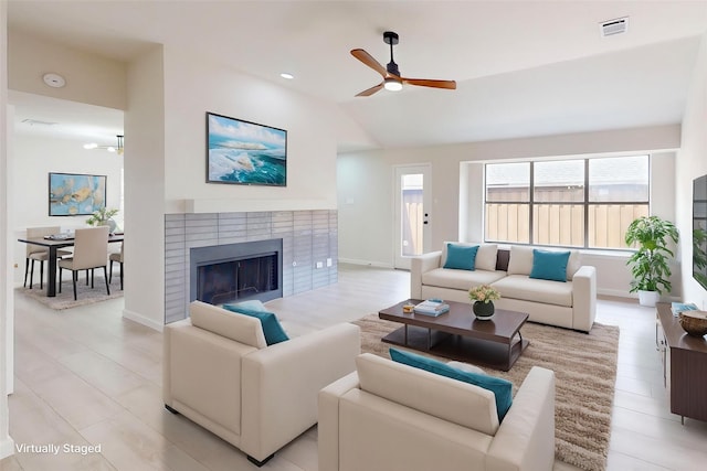 6916 Moccasin Dr, Plano, TX 75023 - living area featuring healthy amount of natural light, a ceiling fan, lofted ceiling, a brick fireplace, and baseboards