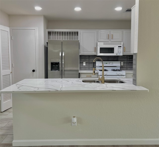 6916 Moccasin Dr, Plano, TX 75023 - kitchen with white appliances, a sink, light stone countertops, white cabinetry, and recessed lighting