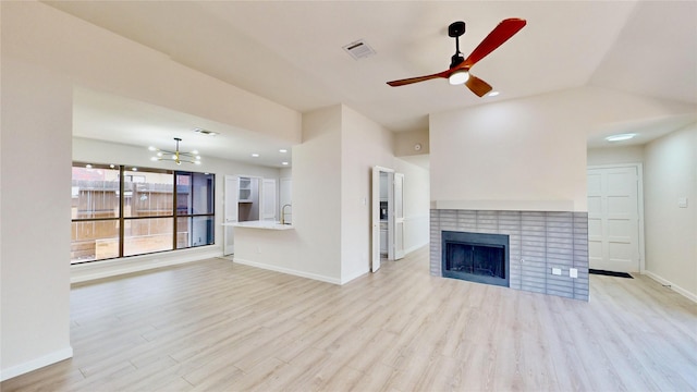 6916 Moccasin Dr, Plano, TX 75023 - unfurnished living room featuring light wood-type flooring, a ceiling fan, a brick fireplace, baseboards, and a chandelier