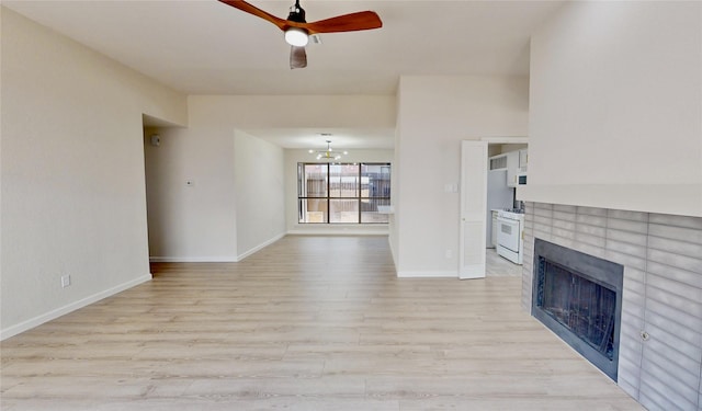 6916 Moccasin Dr, Plano, TX 75023 - unfurnished living room with a tiled fireplace, ceiling fan, light wood finished floors, baseboards, and a chandelier