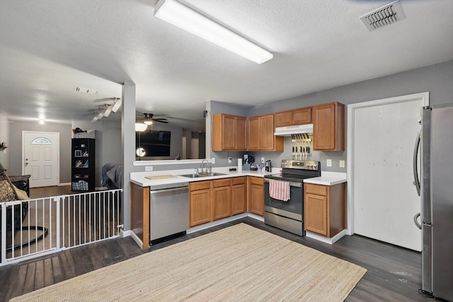848 Cats Eye Dr, Fort Worth, TX 76179 - kitchen featuring stainless steel appliances, under cabinet range hood, dark wood-style flooring, a sink, and a textured ceiling
