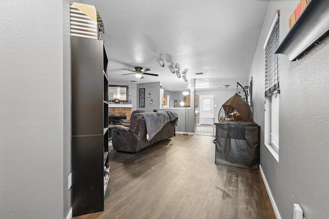 848 Cats Eye Dr, Fort Worth, TX 76179 - living room with wood finished floors, a textured wall, a fireplace, ceiling fan, and baseboards
