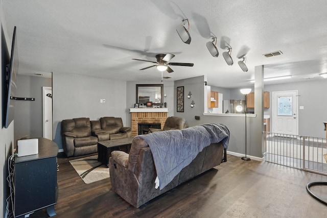 848 Cats Eye Dr, Fort Worth, TX 76179 - living room with dark wood-style flooring, ceiling fan, a fireplace, and baseboards