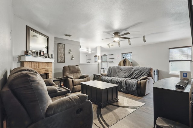 848 Cats Eye Dr, Fort Worth, TX 76179 - living room with ceiling fan, light wood-style flooring, a textured ceiling, plenty of natural light, and a fireplace