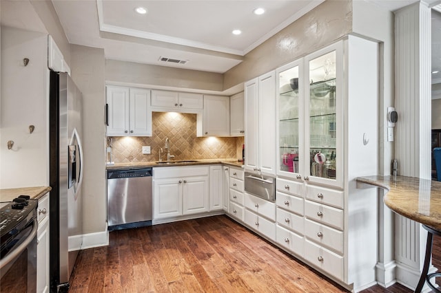 5200 Keller Springs Rd Unit 330, Dallas, TX 75248 - kitchen featuring stainless steel appliances, a sink, a warming drawer, tasteful backsplash, and white cabinetry