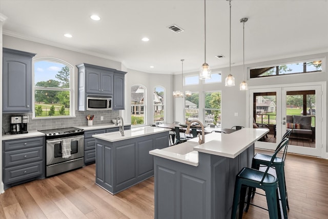125 Oak Creek Dr, Tool, TX 75143 - kitchen with appliances with stainless steel finishes, gray cabinets, an island with sink, light countertops, and recessed lighting