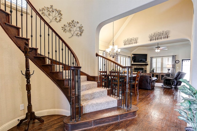 7205 E Nirvana Cir, North Richland Hills, TX 76182 - stairs with wood finished floors, arched walkways, a fireplace, a high ceiling, and ceiling fan