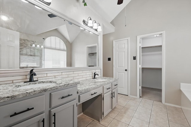 2308 Grandview Dr, Flower Mound, TX 75028 - full bath featuring vaulted ceiling, double vanity, tile patterned floors, a spacious closet, and a tub