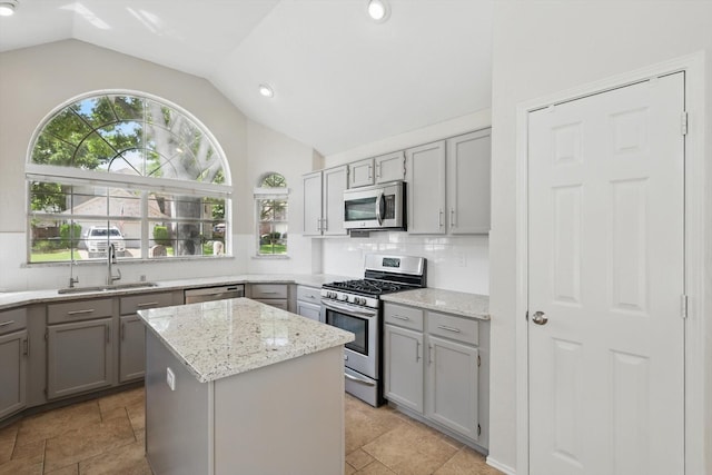2308 Grandview Dr, Flower Mound, TX 75028 - kitchen featuring stainless steel appliances, gray cabinetry, lofted ceiling, a sink, and decorative backsplash