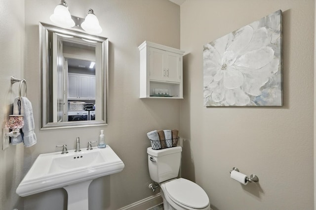 8913 Honeysuckle Dr, Lantana, TX 76226 - bathroom with toilet, washer / clothes dryer, a sink, and baseboards